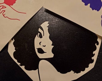 May include: Black and white silhouette of a woman with an afro hairstyle. The woman is looking to the side and has a neutral expression. The silhouette is on a white background.