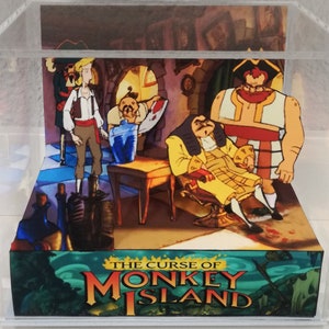 May include: A 3D diorama of a scene from the video game "The Curse of Monkey Island". The diorama features four characters from the game: Guybrush Threepwood, the pirate LeChuck, the governor, and a pirate. The diorama is set in a tavern with a wooden table and chairs. The diorama is made of paper and cardboard and is displayed in a clear acrylic box.