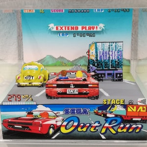 Könnte beinhalten: Ein 3D-Diorama des klassischen Arcade-Spiels Out Run. Das Diorama zeigt einen roten Sportwagen, ein gelbes Auto und einen Sattelschlepper. Der Titel des Spiels, "Out Run", ist in großen, bunten Buchstaben dargestellt. Das Diorama ist vor einem blauen Himmel mit weißen Wolken platziert. Die Punktzahl, die Zeit und die Runde des Spiels werden auf dem Bildschirm angezeigt.