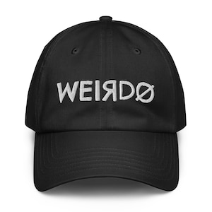 May include: A black baseball cap featuring white embroidered text on the front panel. The word WEIRDO is stitched in a mirrored, inverted font style, with the letter O replaced by a slashed zero symbol, centered above the curved brim.