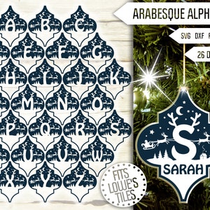 May include: A set of 26 alphabet letters in a white silhouette design, each letter is inside a blue arabesque tile with a winter scene of a sleigh pulled by reindeer and stars. The letters are designed to fit Lowe's tiles. The image also shows a sample ornament with the letter S and the name Sarah.