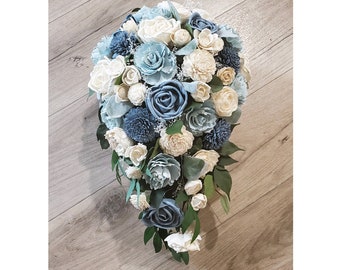 Bouquet da sposa blu polveroso realizzato con fiori da matrimonio in cascata sulla spiaggia in legno Sola, bouquet da damigella d'onore artificiali in azzurro pallido naturale e rosa bianca