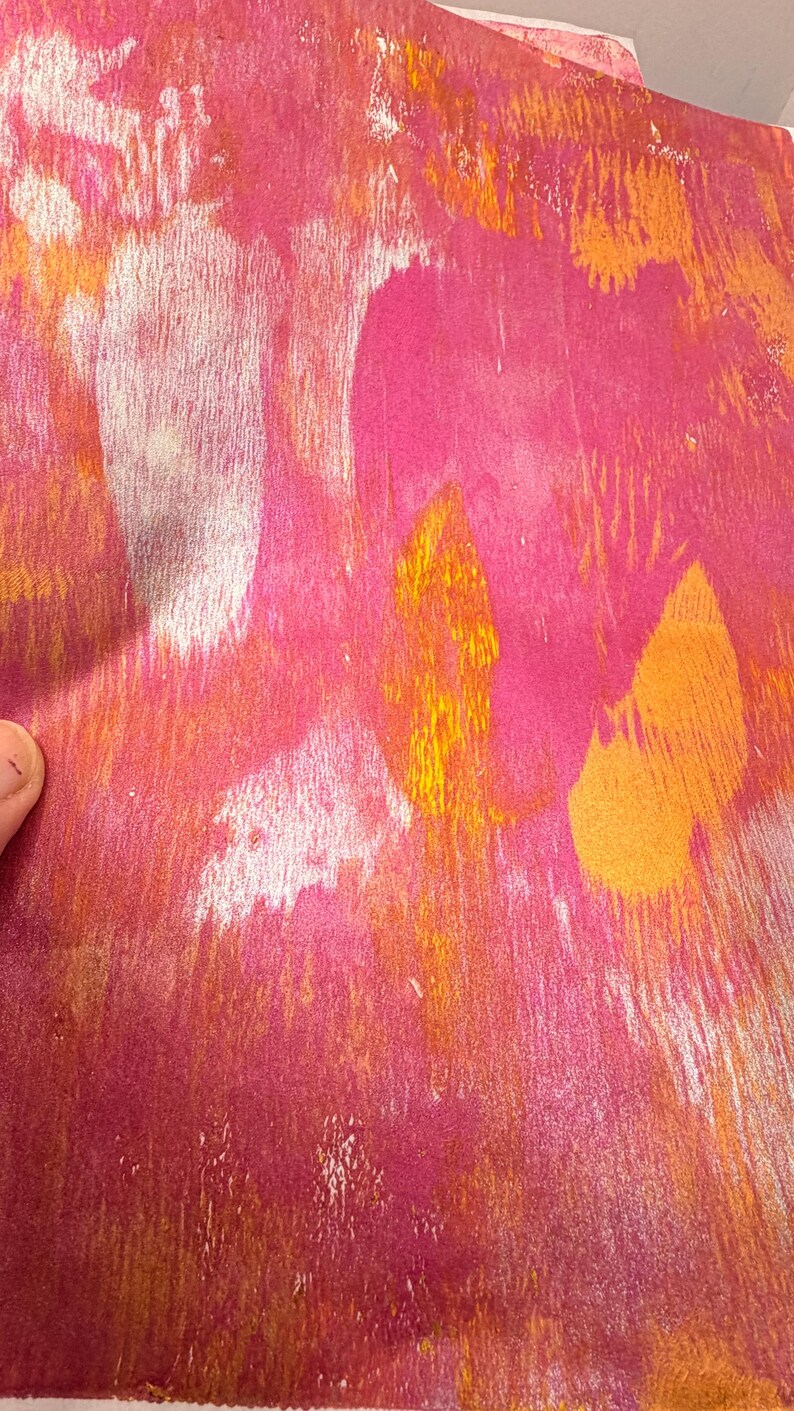 May include: Abstract artwork with a textured appearance. The piece features a blend of pink, orange, and yellow hues, creating a vibrant and dynamic composition. The brushstrokes and color variations add depth and visual interest to the artwork.