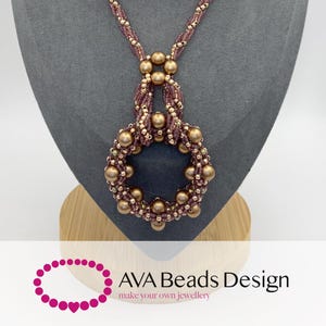 May include: A long necklace featuring a circular pendant made of mauve and metallic gold beads. The chain consists of twisted mauve seed beads accented with small gold beads and larger gold spheres. The text AVA Beads Design is visible.