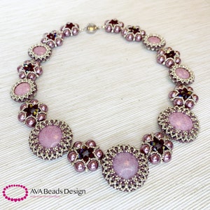 May include: A delicate necklace with a silver and purple color scheme. The necklace features a repeating pattern of small round beads and larger round beads with a textured surface. The necklace is accented with small, dark purple crystals.