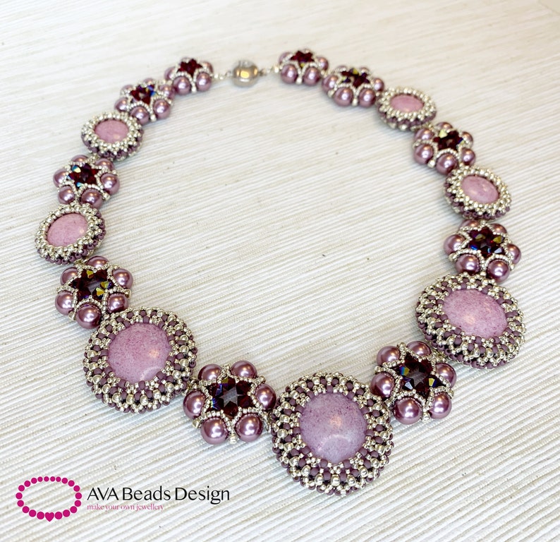 May include: A delicate necklace with a silver and purple color scheme. The necklace features a repeating pattern of small round beads and larger round beads with a textured surface. The necklace is accented with small, dark purple crystals.