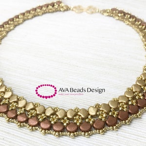 May include: A gold and copper beaded necklace with a layered design. The necklace is made with small, round beads and larger, flat beads in the shape of hearts. The necklace is on a white fabric background. The text "AVA Beads Design" is visible in the image.
