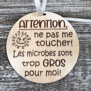 Peut inclure: Une pancarte ronde en bois avec le texte "Attention, ne pas me toucher! Les microbes sont trop GROS pour moi!" et une image de dessin animé d'un virus avec un visage.