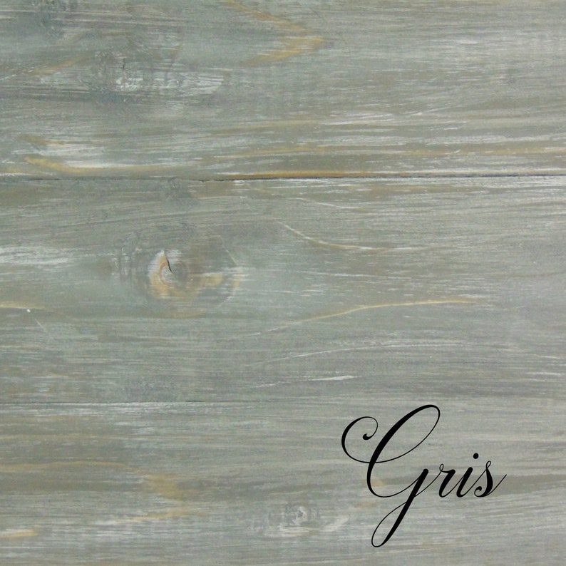 Op de afbeelding: Een close-up van een verweerd grijs houten oppervlak met het woord "Gris" geschreven in zwarte cursieve letters.