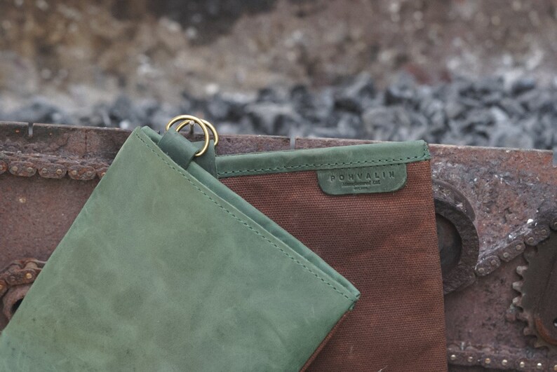 May include: A green leather pouch with a brown canvas pouch inside. The canvas pouch has a brown leather label with the text "POHVALIN" on it.