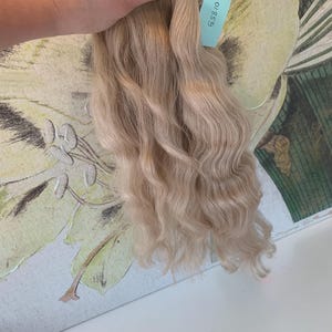 May include: A light blonde wavy human hair weft with a label that reads "63810".