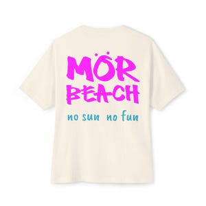 Könnte beinhalten: Cremefarbenes T-Shirt mit den Worten "MÖR BEACH" in leuchtendem Pink und "no sun no fun" in Türkis. Das Shirt hat kurze Ärmel und einen Rundhalsausschnitt, mit der Grafik auf dem Rücken.