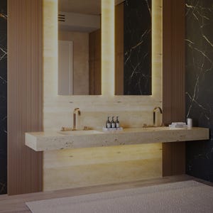 Puede incluir: Un tocador de ba&ntilde;o doble con una encimera larga de piedra beige texturizada, dos lavabos integrados y grifos dorados. Sobre el tocador, dos espejos verticales con iluminaci&oacute;n LED c&aacute;lida integrada est&aacute;n montados en la pared.
