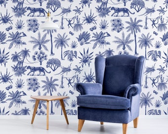 Könnte beinhalten: Ein blauer Sessel mit Flügeln steht vor einer weißen Wand mit einer blauen und weißen gemusterten Tapete, die tropische Pflanzen, Affen und Leoparden zeigt.