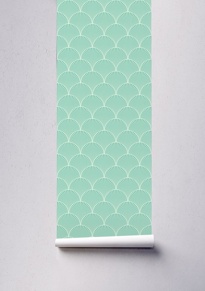 May include: A roll of teal blue wallpaper with a white geometric pattern of overlapping fan shapes.