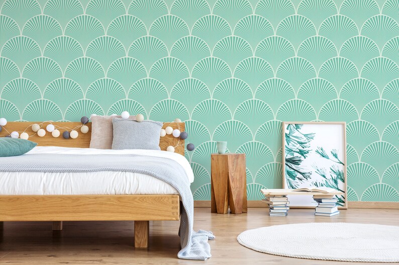 May include: A bedroom with a bed, a side table, and a framed print. The walls are covered in a teal and white geometric wallpaper with a fan-like pattern.