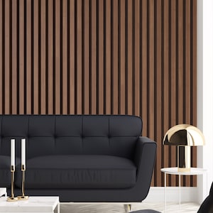 May include: A black leather sofa with a gold metal table lamp and a white side table in front of a wood slat wall.
