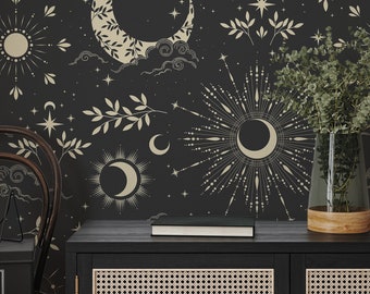 May include: A black cabinet with two doors featuring a woven cane pattern. The cabinet is decorated with a book and a vase of greenery. The wall behind the cabinet is covered in a black and gold wallpaper with a celestial pattern of moons, stars, and suns.