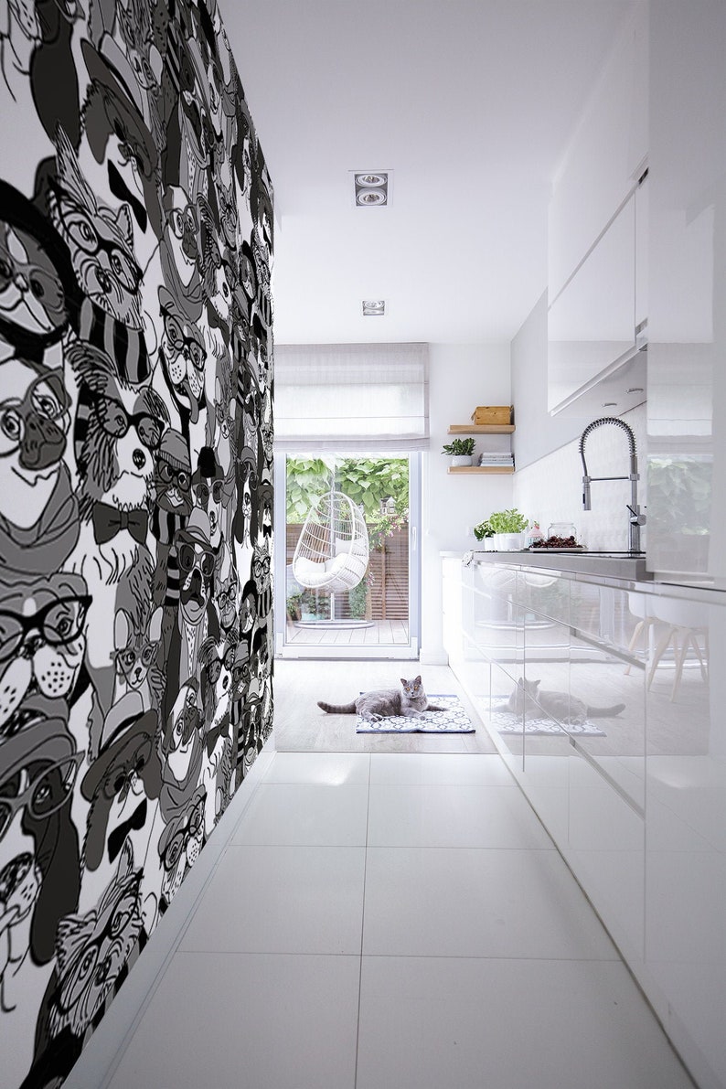 Puede incluir: Una cocina blanca con un papel tapiz estampado en blanco y negro con perros de dibujos animados que llevan sombreros y gafas. Dos gatos est&aacute;n tumbados en una alfombra en el medio de la habitaci&oacute;n.
