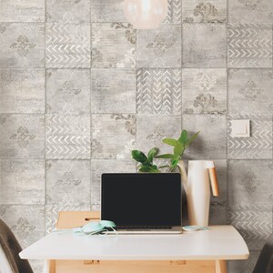May include: A white desk with a laptop, a plant, and a pitcher on it. The desk is in front of a wall with a gray and white patterned tile design. There is a light fixture hanging from the ceiling.