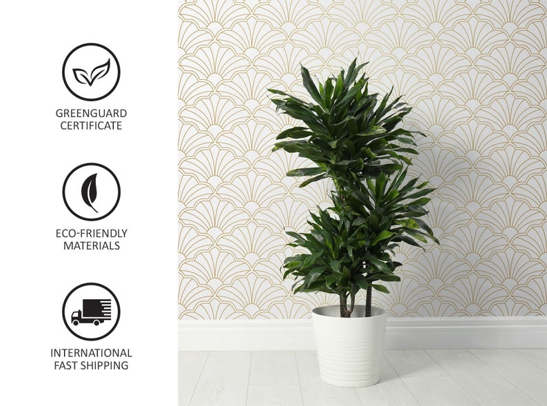 Puede incluir: Una planta verde en maceta con m&uacute;ltiples tallos y hojas en una maceta blanca contra una pared blanca con un patr&oacute;n geom&eacute;trico dorado. La planta est&aacute; en una maceta blanca con una superficie texturizada.