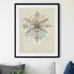 Pode incluir: Um sofá branco com uma manta azul e cinza, duas almofadas e uma pequena mesa auxiliar de madeira. Uma pintura de aquarela emoldurada de um floco de neve pendura na parede acima do sofá.