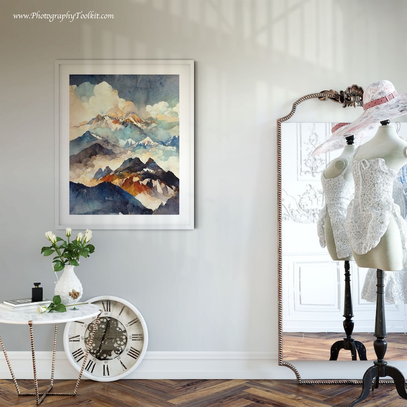 May include: A framed watercolor painting of a mountain range with blue, brown, and white hues. The painting is hanging on a white wall with a mirror and a clock in the foreground.