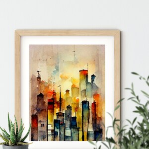 May include: A watercolor painting of a city skyline with tall buildings in shades of orange, yellow, blue, and brown. The buildings are painted in a loose, impressionistic style, with soft edges and flowing lines. The painting is framed in a light wood frame.