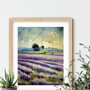 May include: A framed watercolor painting of a lavender field with a few trees in the distance. The sky is a light blue with white clouds. The painting is in a light wood frame.