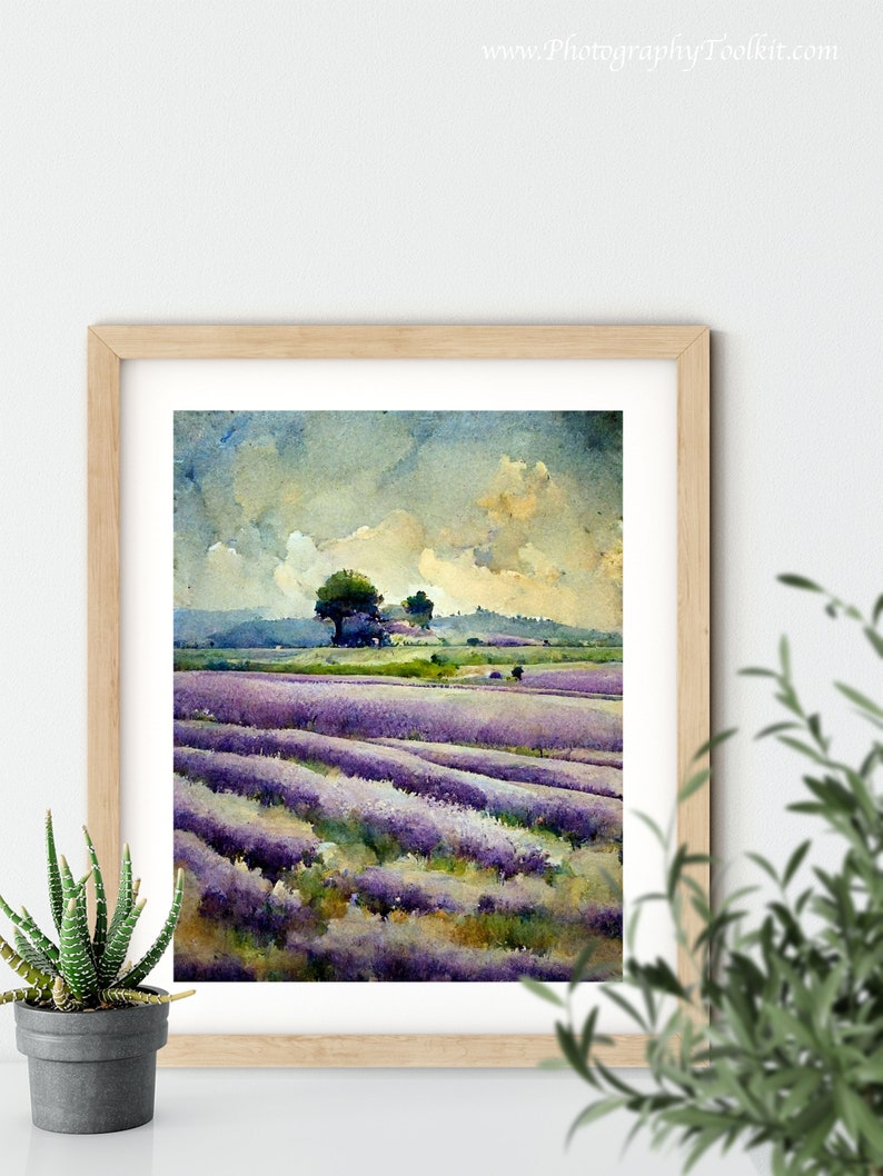 May include: A framed watercolor painting of a lavender field with a few trees in the distance. The sky is a light blue with white clouds. The painting is in a light wood frame.