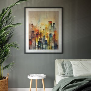 May include: A framed watercolor painting of a city skyline with tall buildings in shades of yellow, orange, red, blue, and green. The buildings are depicted against a light brown background with a hazy, atmospheric effect.