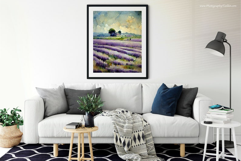 May include: A framed watercolor painting of a lavender field with a small tree in the distance. The painting is in a black frame and is hanging on a white wall.