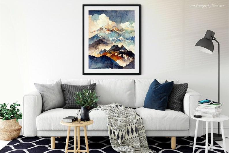 May include: A framed watercolor painting of a mountain range with blue, brown, and white hues. The mountains are layered with clouds and mist, creating a sense of depth and perspective.