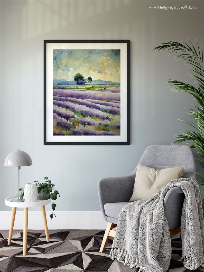 May include: A framed watercolor painting of a lavender field with a small cluster of trees in the distance. The painting is hanging on a light blue wall in a living room setting.