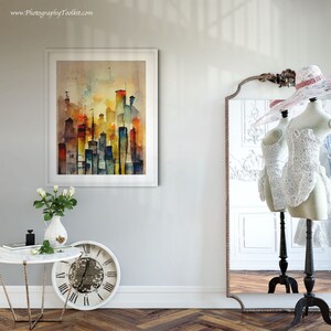 May include: A framed watercolor painting of a city skyline in shades of yellow, orange, blue, and green. The painting is hanging on a white wall next to a full-length mirror with a decorative frame.