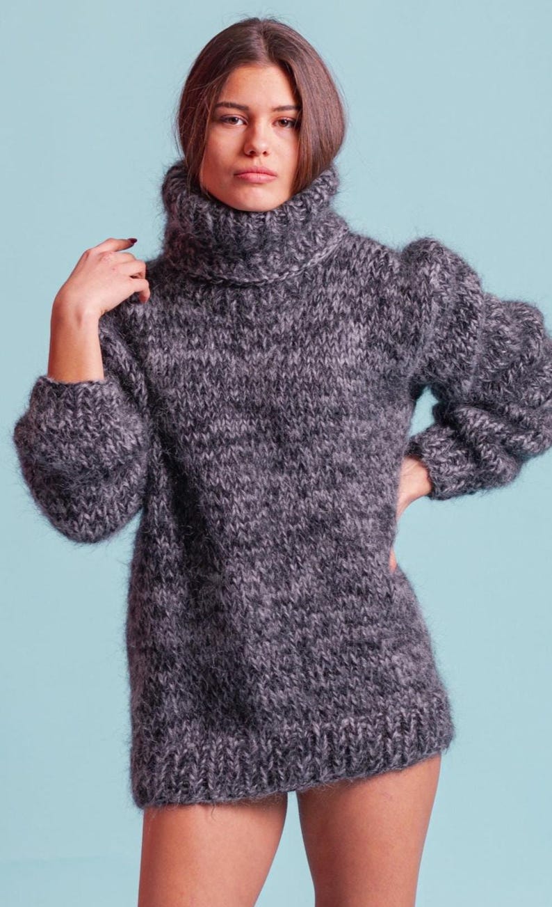 May include: A gray, fuzzy turtleneck sweater with a loose fit and long sleeves.