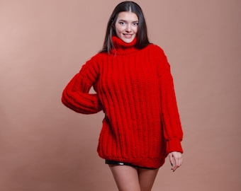 May include: A woman wearing a red turtleneck sweater with a chunky knit texture. The sweater has long sleeves and a relaxed fit.