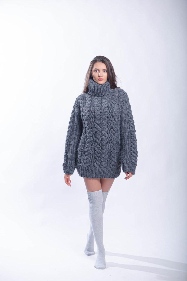 May include: A gray oversized cable knit sweater with a turtleneck.