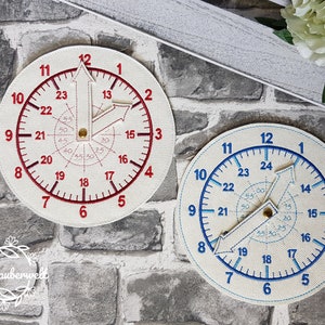 Puede incluir: Dos relojes redondos blancos con números y manecillas rojos y azules. Los relojes tienen un diseño en espiral en el centro con números del 15 al 55.