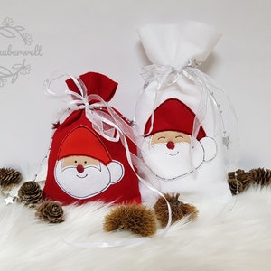 Könnte beinhalten: Zwei Weihnachtsgeschenktüten, eine rote und eine weiße, jeweils mit einem Applikation-Gesicht des Weihnachtsmanns. Die Taschen sind mit weißem Band gebunden und mit silbernen Akzenten verziert. Die rote Tasche hat ein weißes Weihnachtsmann-Gesicht, und die weiße Tasche hat ein rotes Weihnachtsmann-Gesicht.