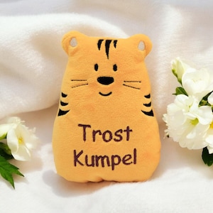 Könnte beinhalten: Ein plüschiger orangefarbener Tiger aus Stoff mit schwarzen Streifen und einem braunen gestickten Gesicht. Der Tiger hat die Worte "Trost Kumpel" auf seiner Brust gestickt.