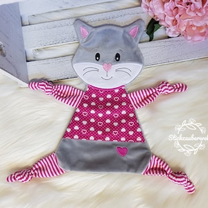 May include: A gray and pink cat-shaped plush toy with a pink heart pattern and white hearts. The toy has knotted arms and legs.
