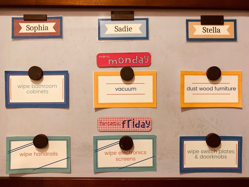 Chore cards displayed on fridge with magnets.