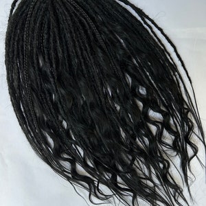 Könnte beinhalten: Ein Satz schwarzer synthetischer Dreadlocks mit welliger Textur für Haarverlängerungen.