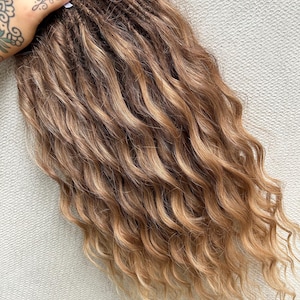 May include: A set of long, wavy, brown and blonde ombre synthetic dreadlocks.