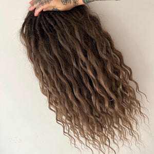 May include: A long, brown, wavy synthetic dreadlock wig.