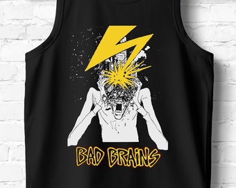 May include: Black tank top with a white graphic of a person with a city exploding out of their head. The graphic is surrounded by a yellow lightning bolt. The text "BAD BRAINS" is printed in yellow below the graphic.