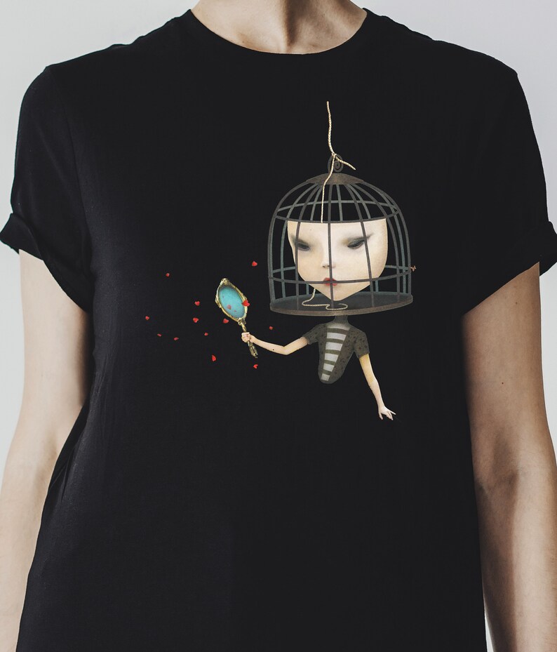 K&ouml;nnte beinhalten: Ein schwarzes T-Shirt mit einem Motiv einer Person mit einem K&auml;fig &uuml;ber dem Kopf, die einen Spiegel h&auml;lt. Die Person tr&auml;gt ein gestreiftes Hemd und hat rote Herzen um sich herum schweben.