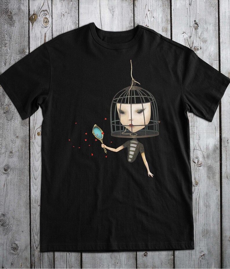 K&ouml;nnte beinhalten: Schwarzes T-Shirt mit einem Motiv einer Person, deren Kopf in einem Vogelk&auml;fig steckt und einen Spiegel h&auml;lt. Rote Herzen sind um die Person herum verstreut.