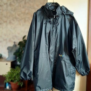 May include: Black hooded jacket with a zipper closure and a logo that says "Overtime" on the front.